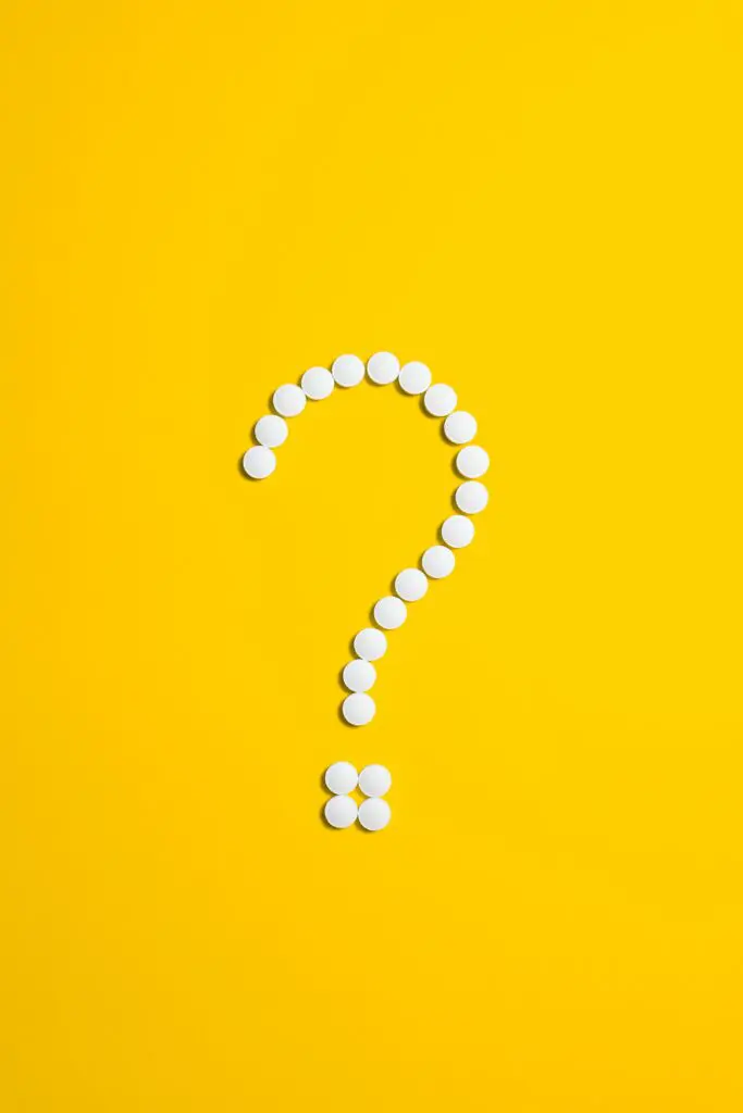 Pills placed in a question mark shape