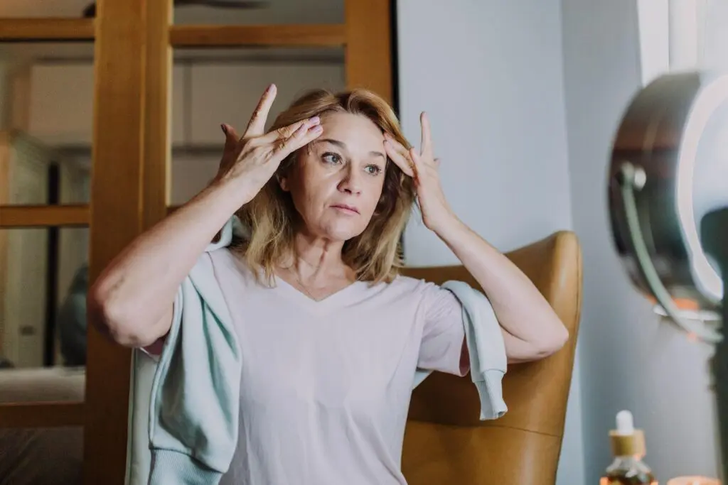 Woman standing with her hands on her forehead