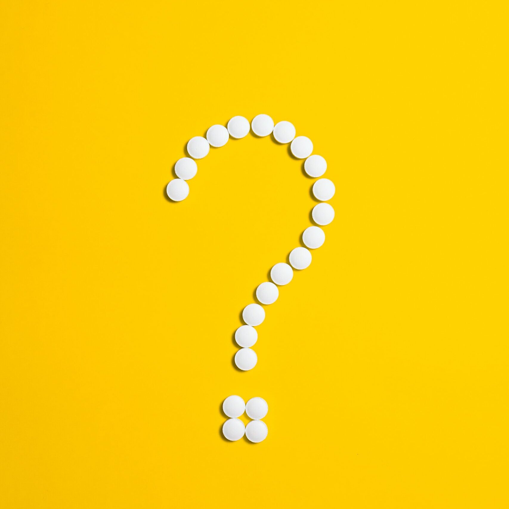 Pills placed in a question mark shape